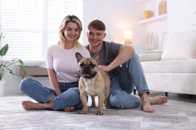 Photo of Happy couple with cute dog at home