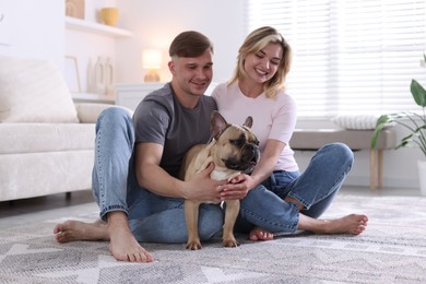 Photo of Happy couple with cute dog at home