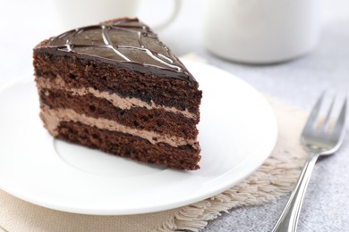 Photo of Piece of delicious chocolate cake and fork on table, closeup
