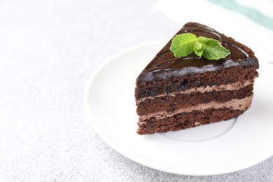 Photo of Piece of delicious chocolate cake with mint on grey table, closeup. Space for text