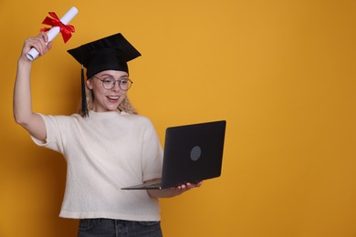 Photo of Happy student with diploma and laptop after graduation on orange background. Space for text