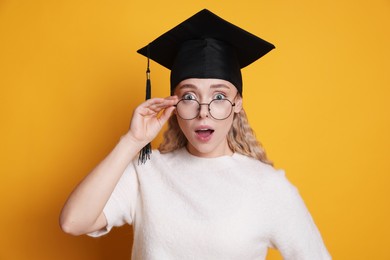 Photo of Excited student after graduation on orange background