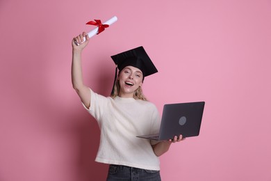 Photo of Happy student with diploma and laptop after graduation on pink background