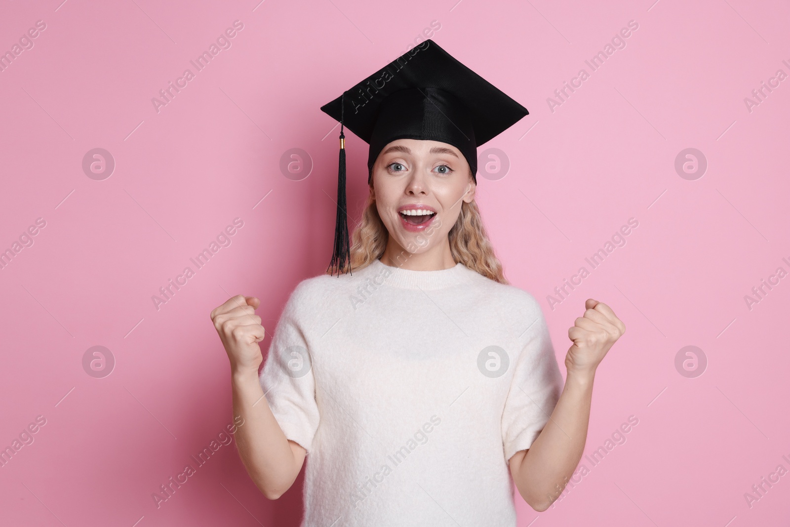 Happy student after graduation on pink background Photo of Happy student after graduation on pink background