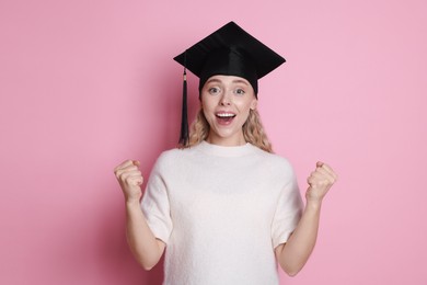 Photo of Happy student after graduation on pink background