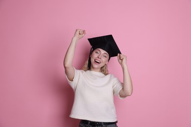 Photo of Happy student after graduation on pink background
