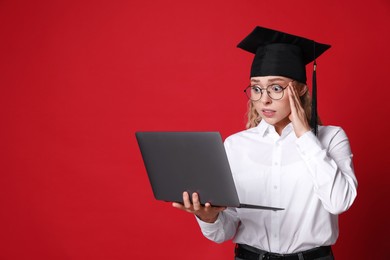 Photo of Excited student with laptop before graduation on red background. Space for text
