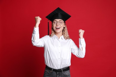 Photo of Happy student after graduation on red background