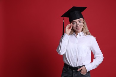 Photo of Happy student after graduation on red background. Space for text