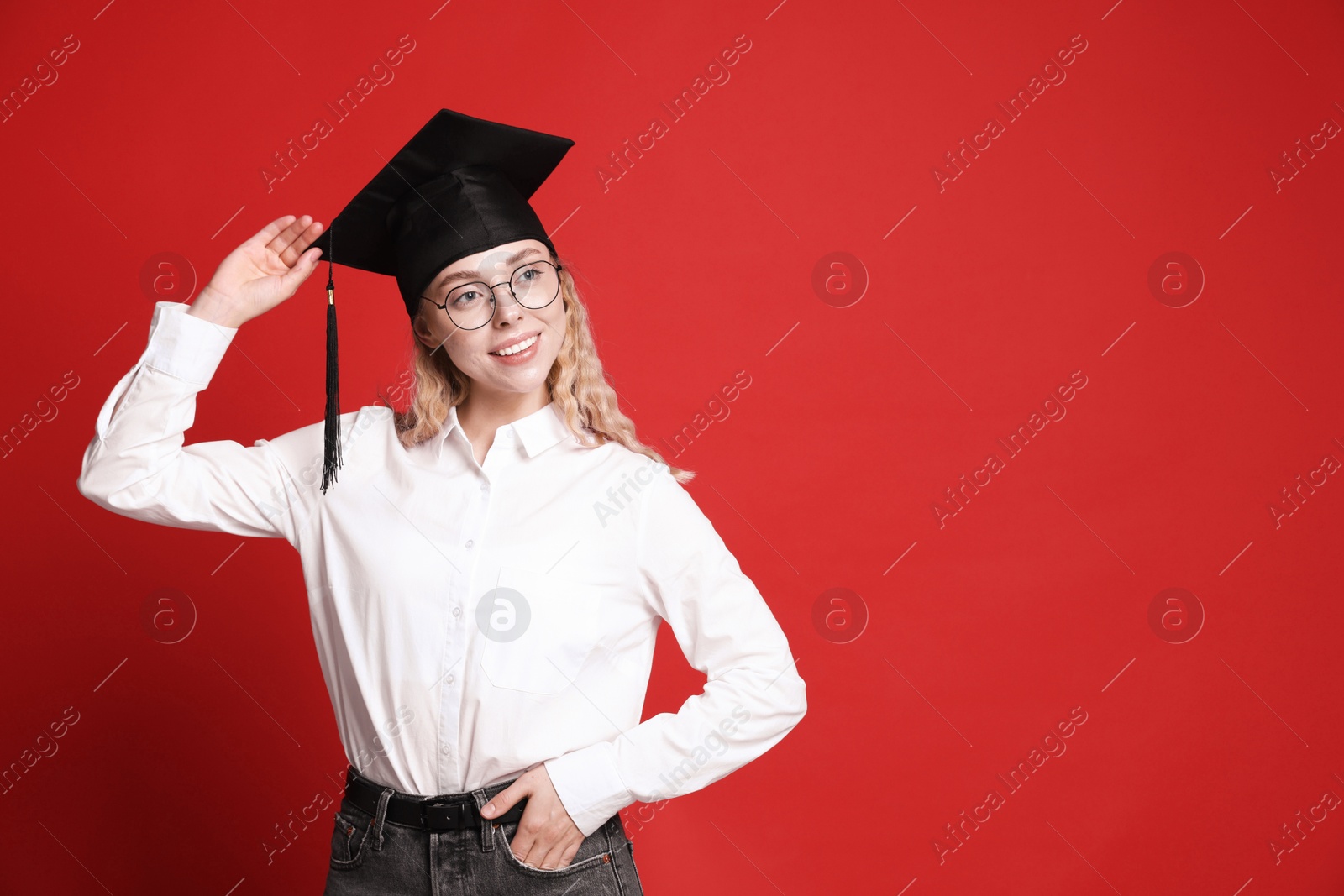 Happy student after graduation on red background. Space for text Photo of Happy student after graduation on red background. Space for text