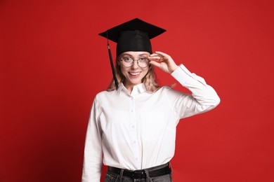 Photo of Happy student after graduation on red background