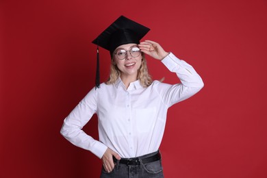 Photo of Happy student after graduation on red background