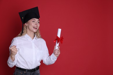 Photo of Happy student with diploma after graduation on red background. Space for text