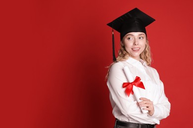 Photo of Happy student with diploma after graduation on red background. Space for text