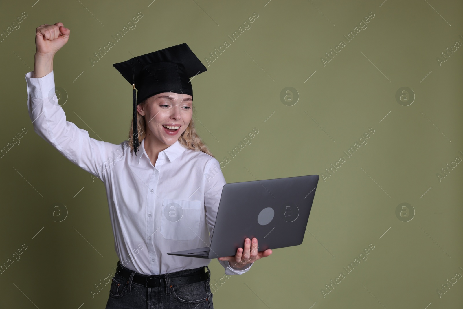 Happy student with laptop after graduation on green background. Space for text Photo of Happy student with laptop after graduation on green background. Space for text