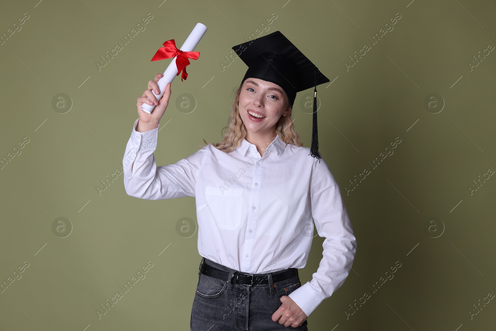 Happy student with diploma after graduation on green background Photo of Happy student with diploma after graduation on green background
