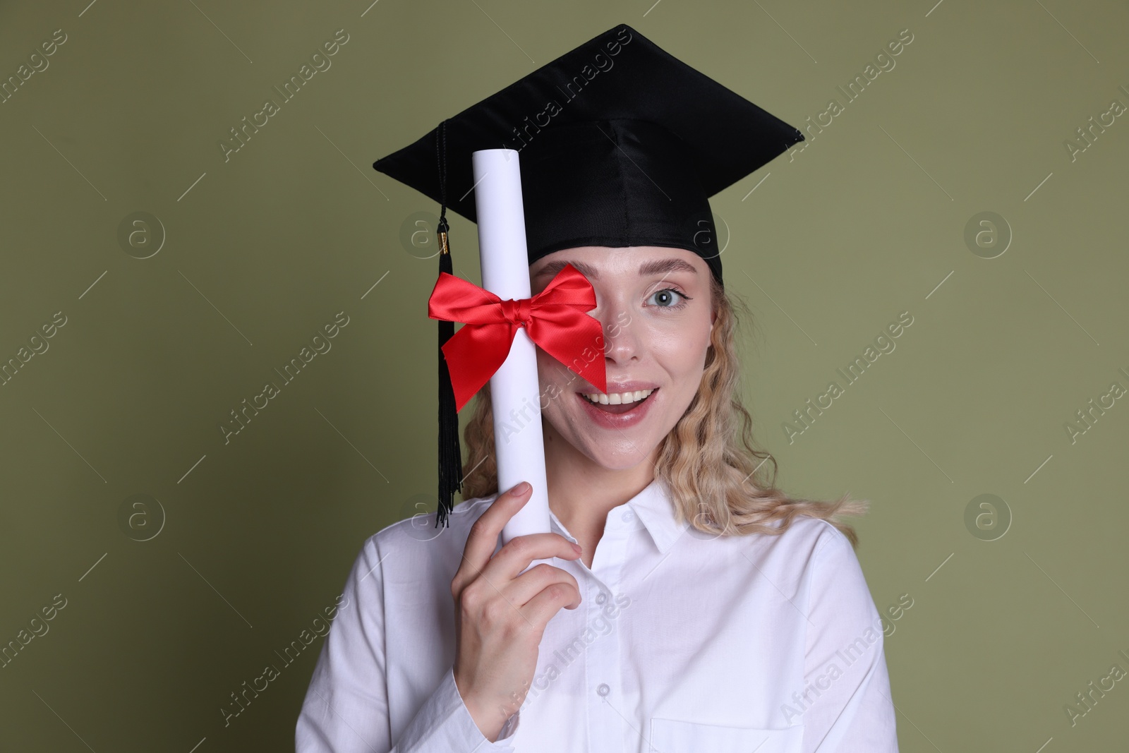 Happy student with diploma after graduation on green background Photo of Happy student with diploma after graduation on green background
