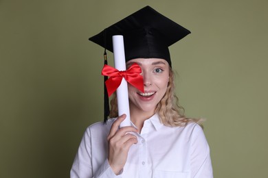 Photo of Happy student with diploma after graduation on green background