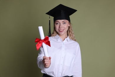 Photo of Happy student with diploma after graduation on green background