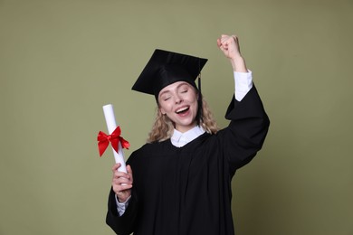 Photo of Happy student with diploma after graduation on green background