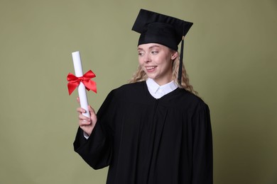 Photo of Happy student with diploma after graduation on green background