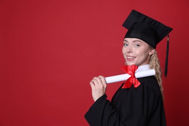 Photo of Happy student with diploma after graduation on red background. Space for text