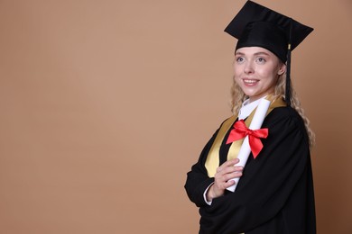 Photo of Happy student with diploma after graduation on beige background. Space for text
