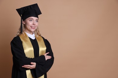 Photo of Happy student with crossed arms after graduation on beige background. Space for text