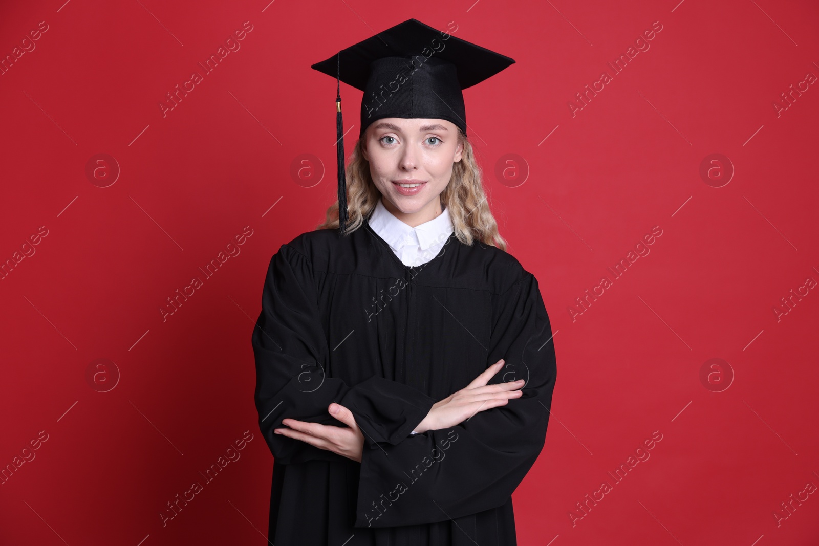 Happy student after graduation on red background Photo of Happy student after graduation on red background