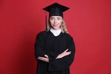 Photo of Happy student after graduation on red background