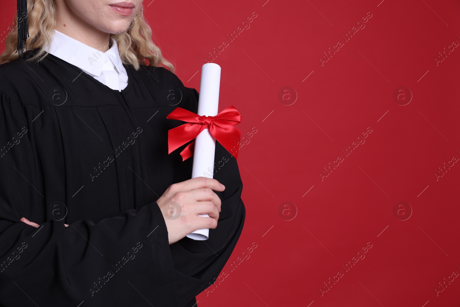 Student with diploma after graduation on red background, closeup. Space for text Photo of Student with diploma after graduation on red background, closeup. Space for text