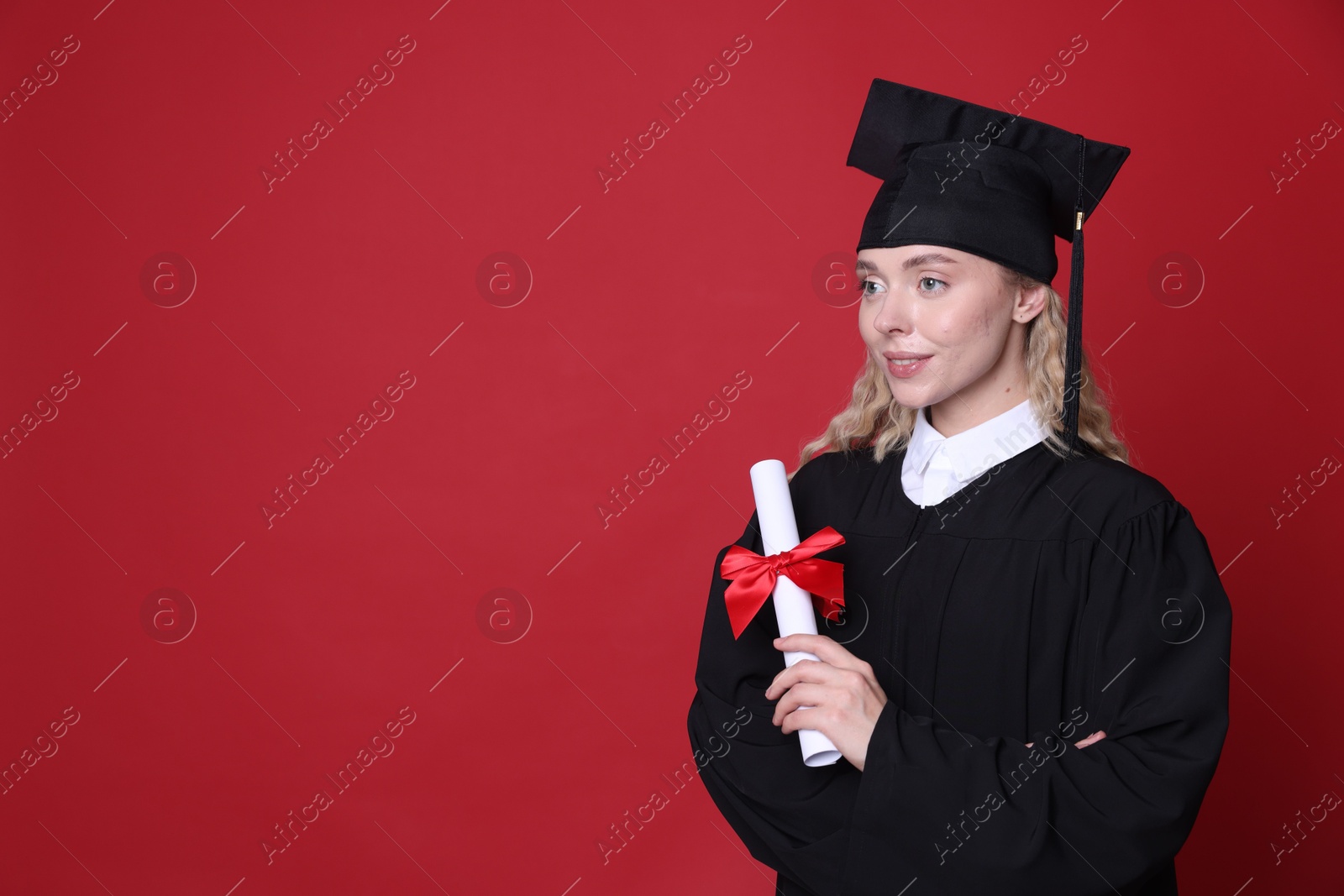 Happy student with diploma after graduation on red background. Space for text Photo of Happy student with diploma after graduation on red background. Space for text