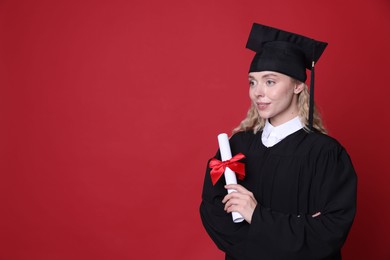 Photo of Happy student with diploma after graduation on red background. Space for text