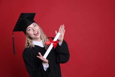 Photo of Happy student with diploma after graduation on red background. Space for text