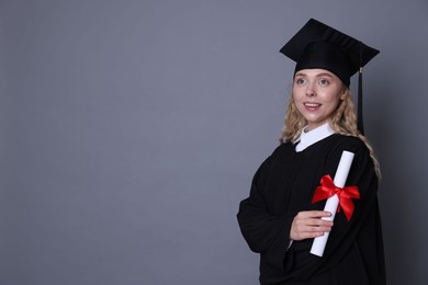 Photo of Happy student with diploma after graduation on grey background. Space for text