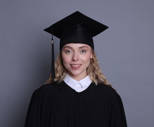 Photo of Happy student after graduation on grey background