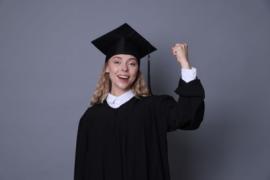 Photo of Happy student after graduation on grey background