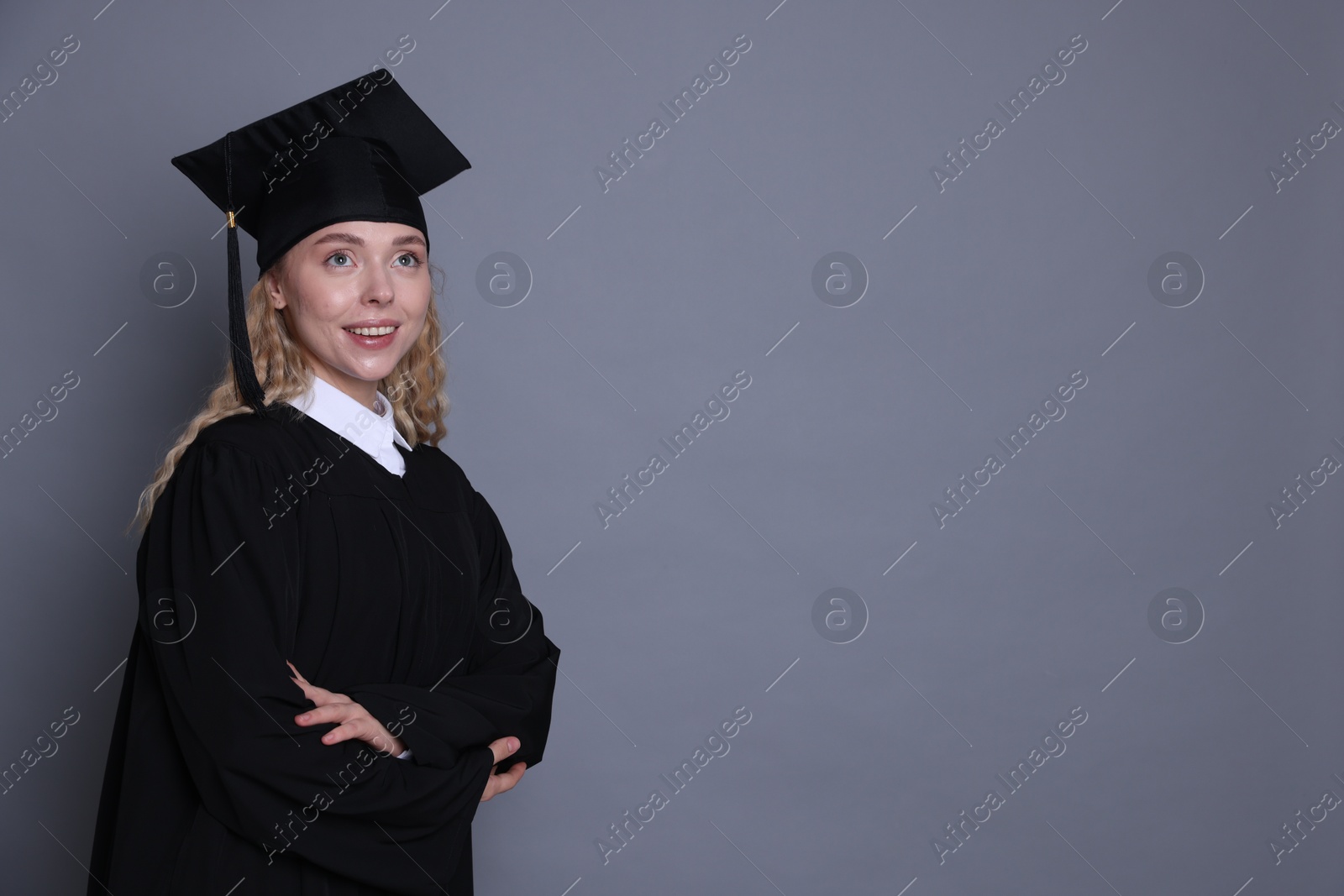 Happy student after graduation on grey background. Space for text Photo of Happy student after graduation on grey background. Space for text