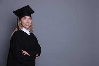 Photo of Happy student after graduation on grey background. Space for text