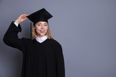 Photo of Happy student after graduation on grey background. Space for text