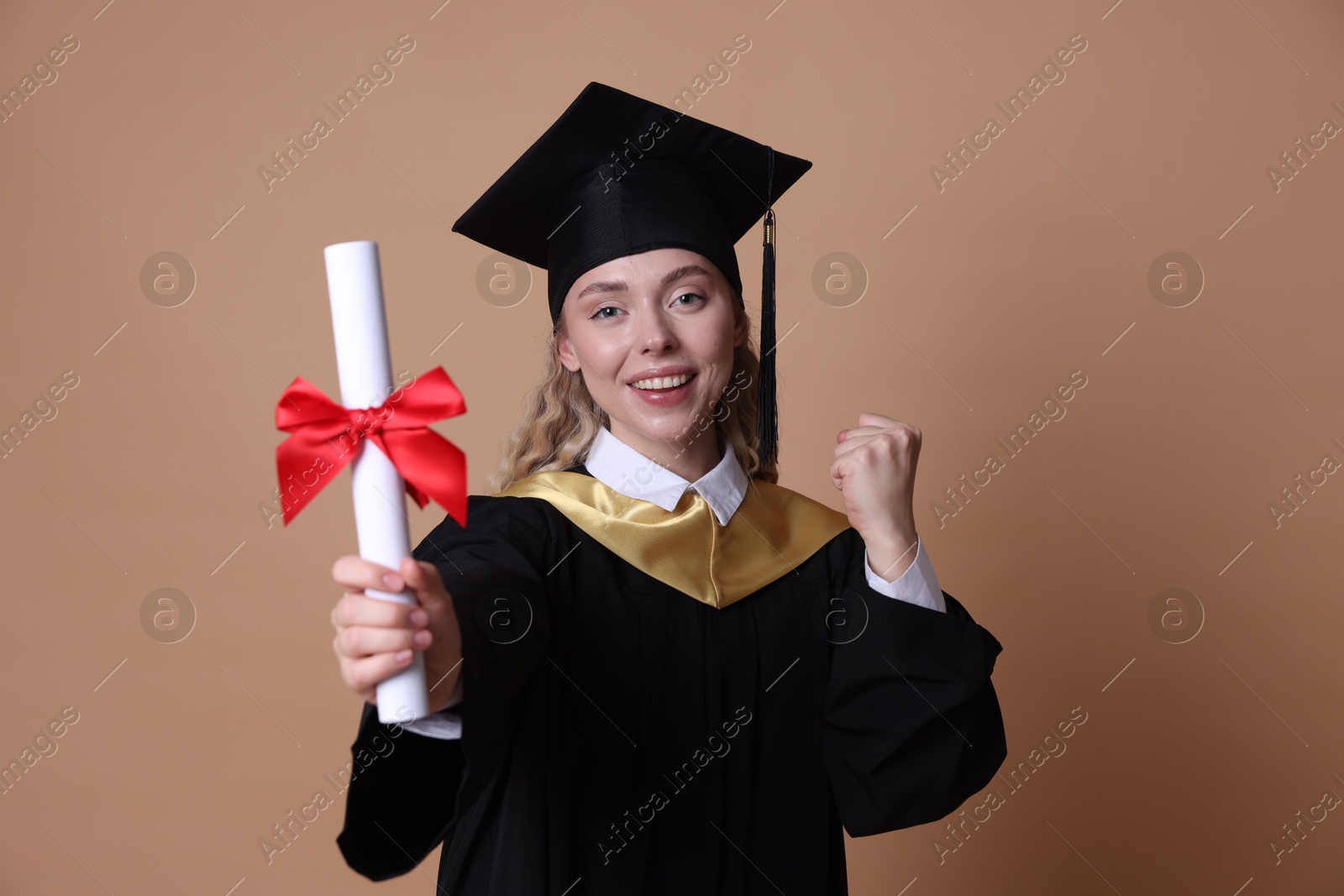 Happy student with diploma after graduation on beige background, selective focus Photo of Happy student with diploma after graduation on beige background, selective focus