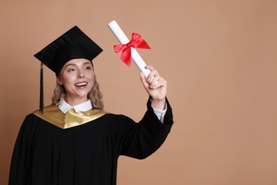 Photo of Happy student with diploma after graduation on beige background. Space for text