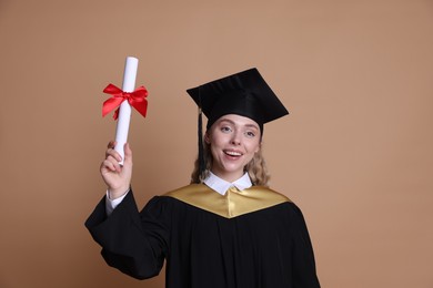 Photo of Happy student with diploma after graduation on beige background