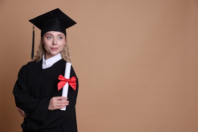 Photo of Happy student with diploma after graduation on beige background. Space for text