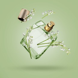Image of Lilies of the valley and bottle of perfume in air on light green background