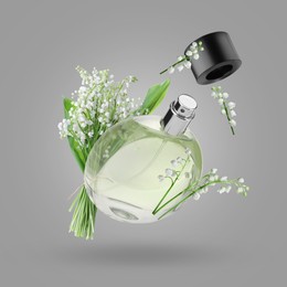 Image of Lilies of the valley and bottle of perfume in air on grey background