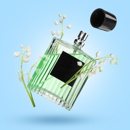 Image of Lilies of the valley and bottle of perfume in air on light blue background