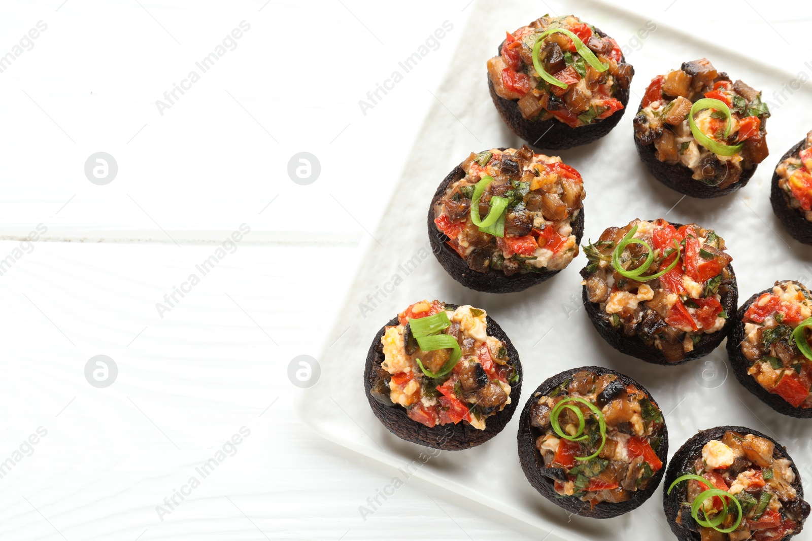 Delicious stuffed mushrooms on white wooden table, top view. Space for text Photo of Delicious stuffed mushrooms on white wooden table, top view. Space for text