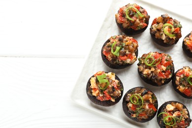 Photo of Delicious stuffed mushrooms on white wooden table, top view. Space for text
