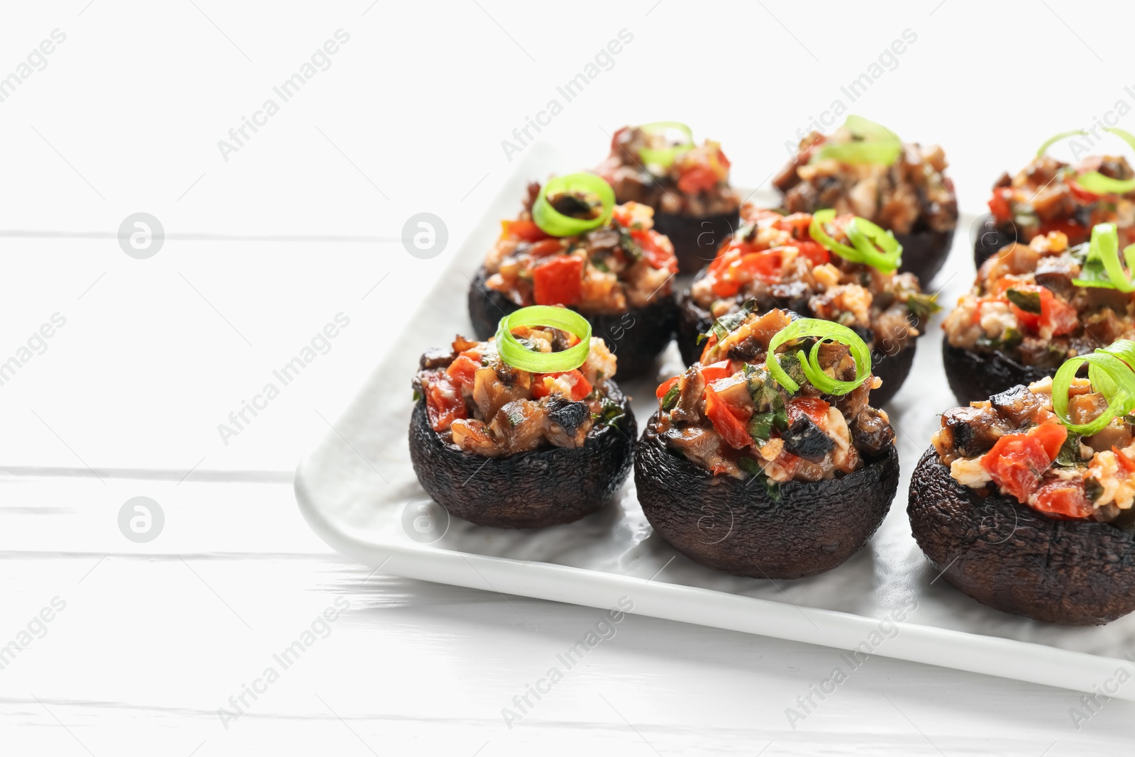 Delicious stuffed mushrooms on white wooden table, closeup. Space for text Photo of Delicious stuffed mushrooms on white wooden table, closeup. Space for text
